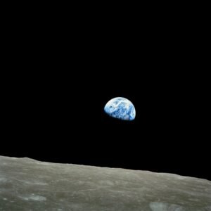 Vue spectaculaire de la Terre depuis la surface de la Lune. La planète bleue apparaît majestueusement dans le ciel noir de l'espace, offrant un contraste saisissant avec le paysage lunaire désertique. Cette photo met en lumière la distance entre la Terre et la Lune, tout en soulignant la beauté et la fragilité de notre planète et de ses ressources vue de l'espace.